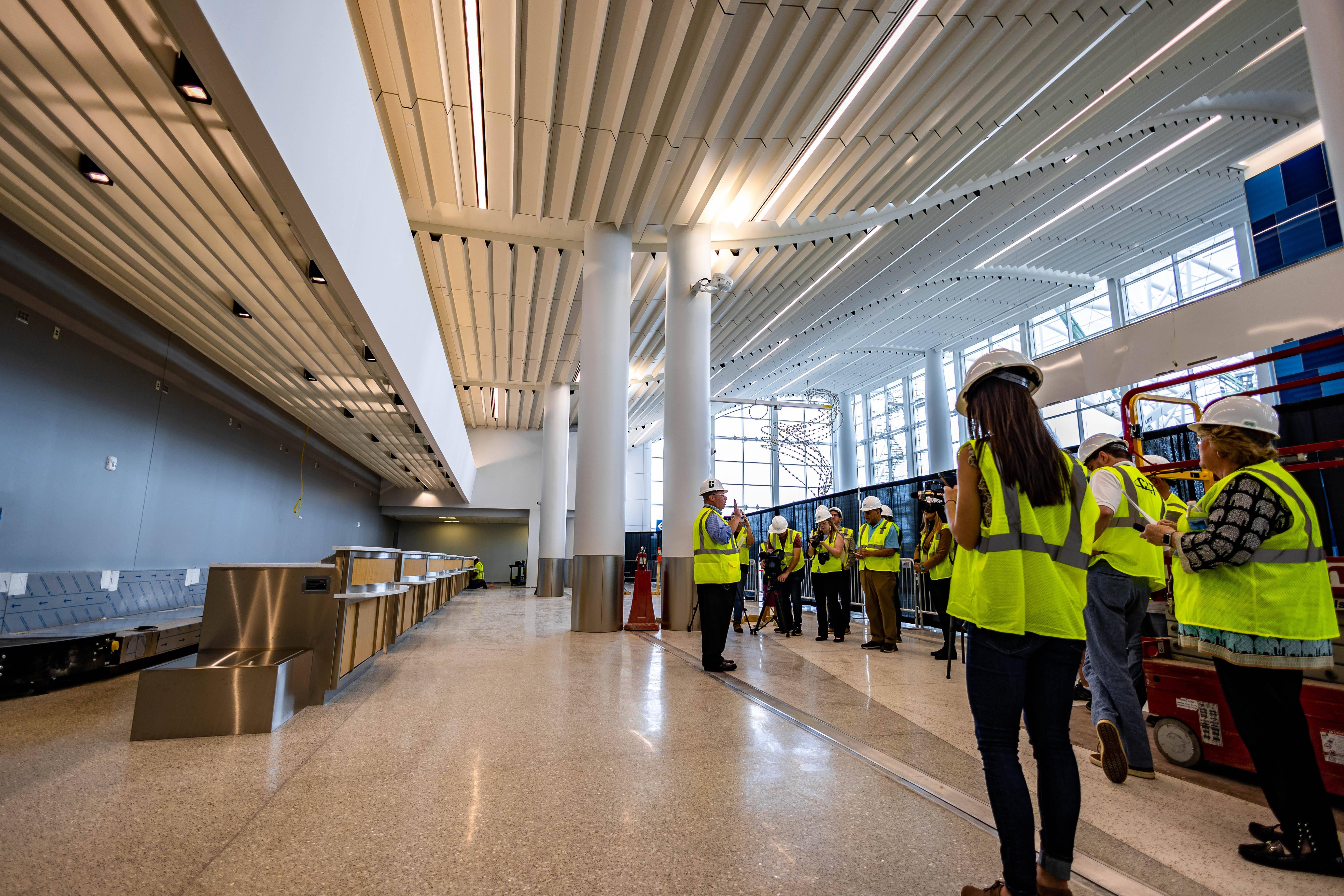 a tour group observes the new ticket counters in the east terminal lobby